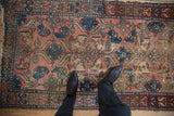 Antique Lilihan rug detail: serpent border, serrated leaves, palmettes, and worn rose, blue pile.