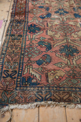 Worn dusty rose field of an antique Lilihan rug, with sapphire blue palmettes and geometric border.