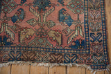 Tattered fringe and dusty rose field with geometric border of an antique Lilihan rug.