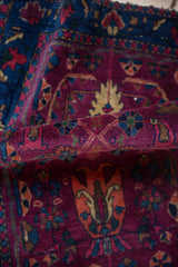 Deep burgundy Farahan Sarouk rug showcasing sapphire and tangerine tulip design elements.