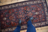 Vintage Malayer Persian rug runner shown for scale, with its navy blue field and geometric vinery.
