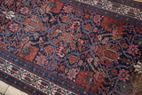 Intricate rainbow-shaded vines and floral motifs on a vintage Persian Malayer rug runner.