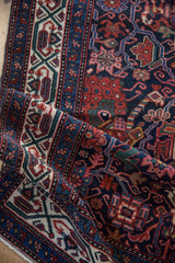 Folded corner of the vintage Malayer runner highlighting its intricate geometric borders and short pile.