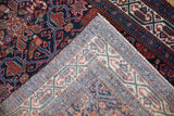 Corner detail of a vintage Persian Malayer rug showing the hand-knotted back and deep navy pile.