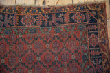 Antique Qashqai rug border displaying charcoal navy blue geometric floral gul and tattered fringe.