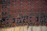 Antique Qashqai rug corner, charcoal navy border with geometric love birds, tattered fringe.