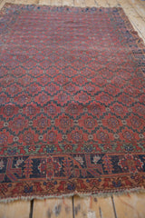 Antique Qashqai rug's red field lattice pattern with charcoal navy botehs and mostly even wear.