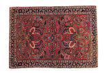 Vintage Sarouk rug, brick red field, dense navy and cream floral bouquets.