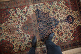 Antique Farahan Sarouk rug detail: navy medallion, cochineal red, ivory floral field, with rich patina.