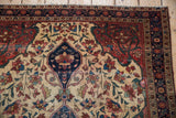 Farahan Sarouk rug: navy medallion fragment, ivory field, colorful vinery, and ornate borders.
