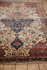 Antique Farahan Sarouk rug's navy medallion, ivory field, and detailed floral vinery with soft patina.