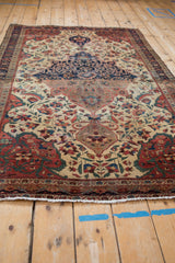 Antique Farahan Sarouk rug displaying ivory fringe, intricate border, and time-softened floral field.