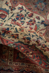 Folded antique Farahan Sarouk rug, detailing red, blue, green vinery, floral blossoms, and abrash.