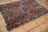 Lilihan rug corner showcasing a navy vine border and tattered fringe with wear.