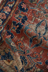 Vintage Lilihan rug, close-up of cherry red field with navy floral arabesques, foundation wear.