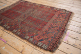 Vintage Ersari rug border in cherry red and dusty teal, showing ram's horn motifs and heavy wear.