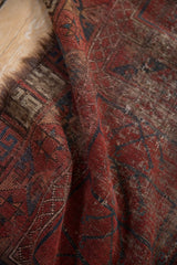 Textured close-up of vintage Ersari rug, highlighting hard wear and rich red brown tones.