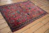 Persian Lilihan rug corner, featuring triple meandering vine border and time-softened red tones.