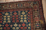 Antique Hamadan rug corner detail, highlighting geometric border with madder red and navy motifs, fringe.