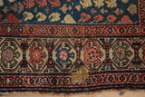 Geometric turtle motif border and navy field of an antique Hamadan rug, showing foundation.