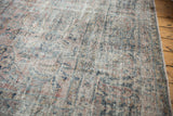 Distressed vintage Mahal carpet detail, low pile revealing faded dusty pink and teal patterns.
