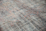 Distressed vintage Mahal carpet with faded pink and teal floral design and visible foundation.