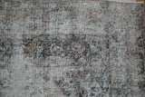 Extensive wear on an antique Kerman carpet reveals the ivory foundation and dark pattern remnants.
