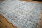 Angled view of a distressed Kerman carpet showing its textured low pile and overall patina.