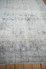 Low angle highlights the worn pile and visible foundation of a distressed antique Kerman carpet.