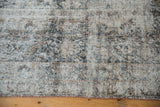 Distressed texture of an antique Kerman carpet with low pile and visible cotton foundation.