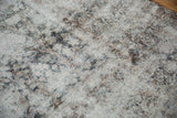 Worn pile on a distressed Kerman carpet reveals knot heads and the ivory foundation.