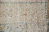 Detail of heavy wear on a vintage Meshed carpet, showing the exposed ivory foundation grid.