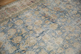 Decorative wear on a vintage Persian carpet showing sand-colored florals over an exposed ivory foundation.