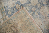 The hand-knotted back and distressed texture of a vintage Persian Meshed carpet's corner.