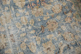Detailed texture of a distressed vintage rug with worn pile and exposed foundation.