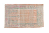Distressed Oushak prayer rug in faded apricot with a mint green and magenta geometric border.