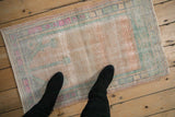 A standing perspective showing the scale of a distressed Oushak rug mat.