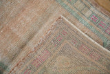 The hand-knotted foundation and intact side cord of a distressed vintage Turkish Oushak rug mat.