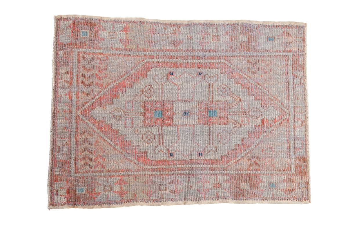 Vintage distressed Oushak rug with a stepped diamond medallion in pale burnt orange, ivory, and dusty turquoise.