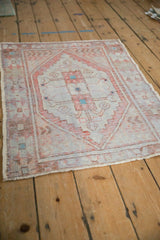 Angled view of a vintage Oushak rug, showing its distressed texture and faded geometric medallion design.