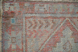 Distressed wear to the foundation and knot heads on a vintage hand-knotted Oushak rug.