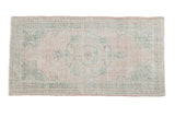 Distressed vintage Oushak rug runner with faded cream and muted green roundel medallion, 2'7
