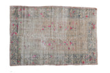Distressed vintage Oushak rug, faded ivory, fuchsia blossoms, with a muted vine border.