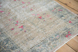 Distressed vintage Oushak rug texture, highlighting fuchsia blossoms and muted ivory tones.