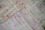 Textured, distressed pile with fuchsia design, showing the woven foundation of the vintage Oushak rug.
