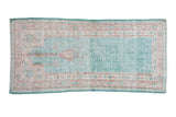Distressed vintage Oushak rug runner featuring a faded ocean green prayer motif and pale terracotta borders, 2'7
