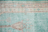 Distressed Oushak rug pile texture in bright ocean green, ivory, and pale terracotta tones.