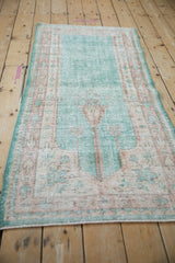 Vintage distressed Oushak runner, featuring bright ocean green with faded motifs and visible knot heads.