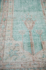 Distressed pile texture on a vintage Oushak runner, with soft ocean green and terracotta.
