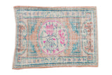 Vintage distressed Oushak rug with a fuchsia rose medallion, dusty coral field and pale turquoise accents.